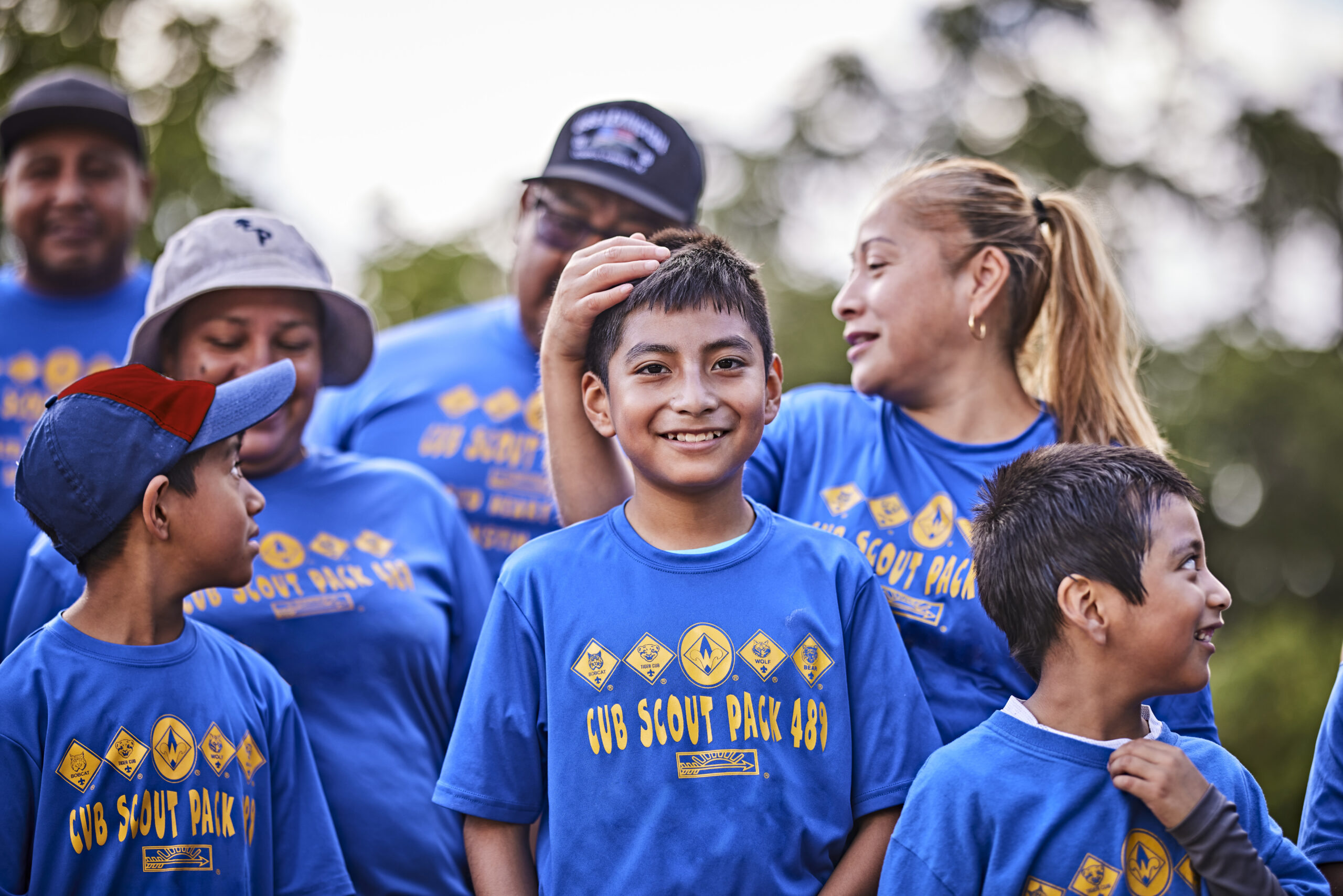Cub Scouts with their moms and dads, posing for the camera; family